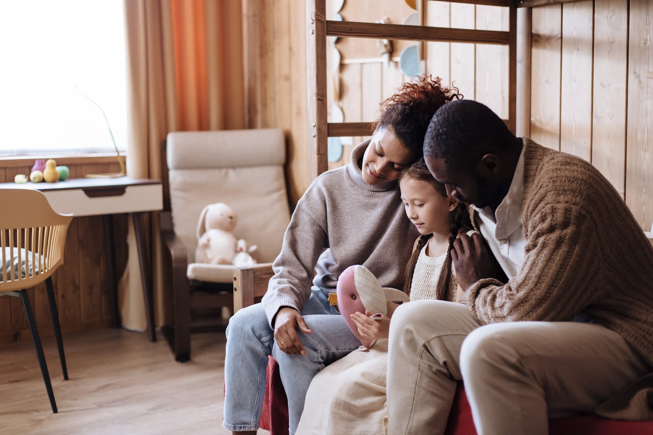 Parents hugging child with stuffed toy