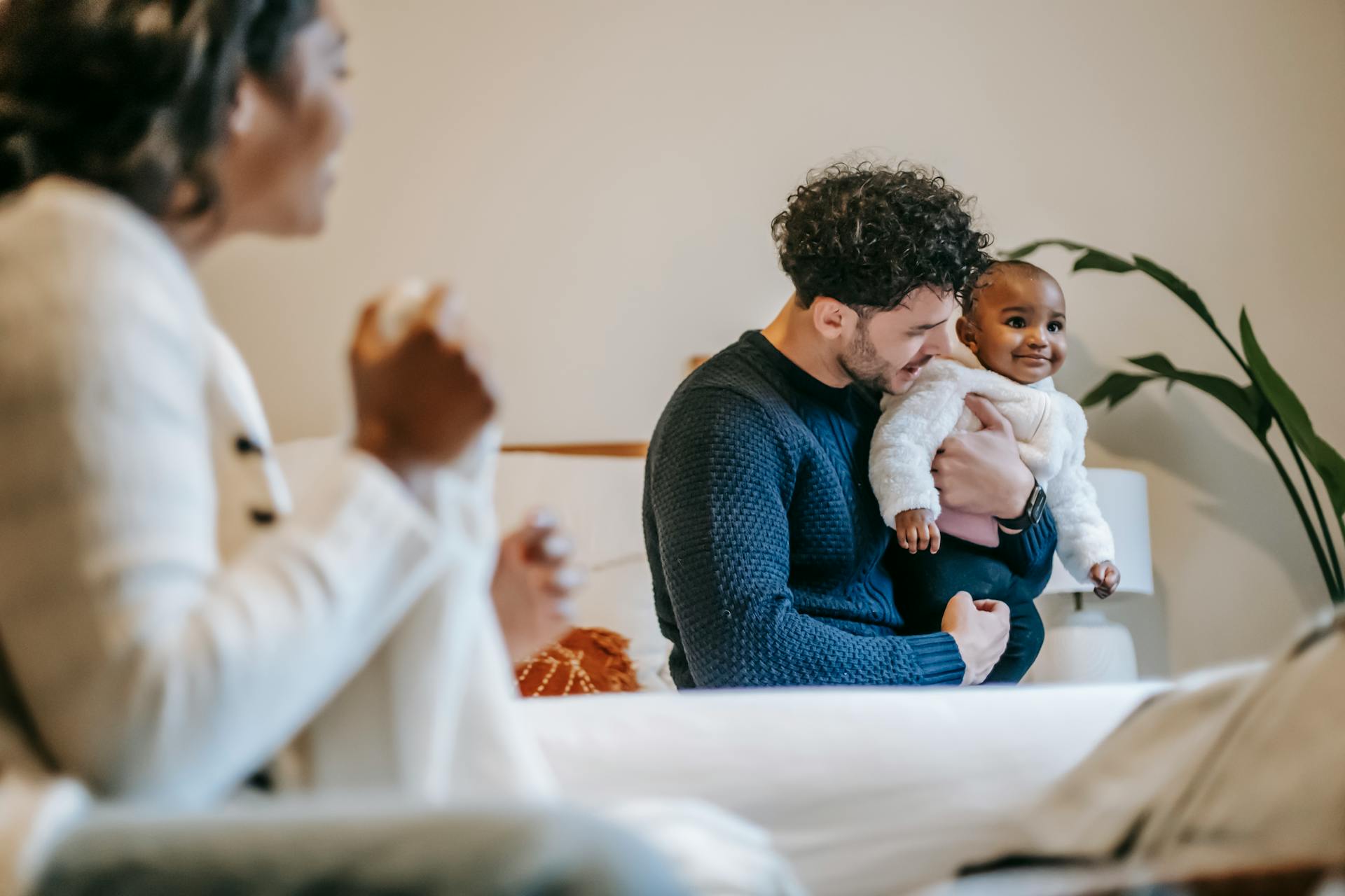 Father holding smiling baby in living room